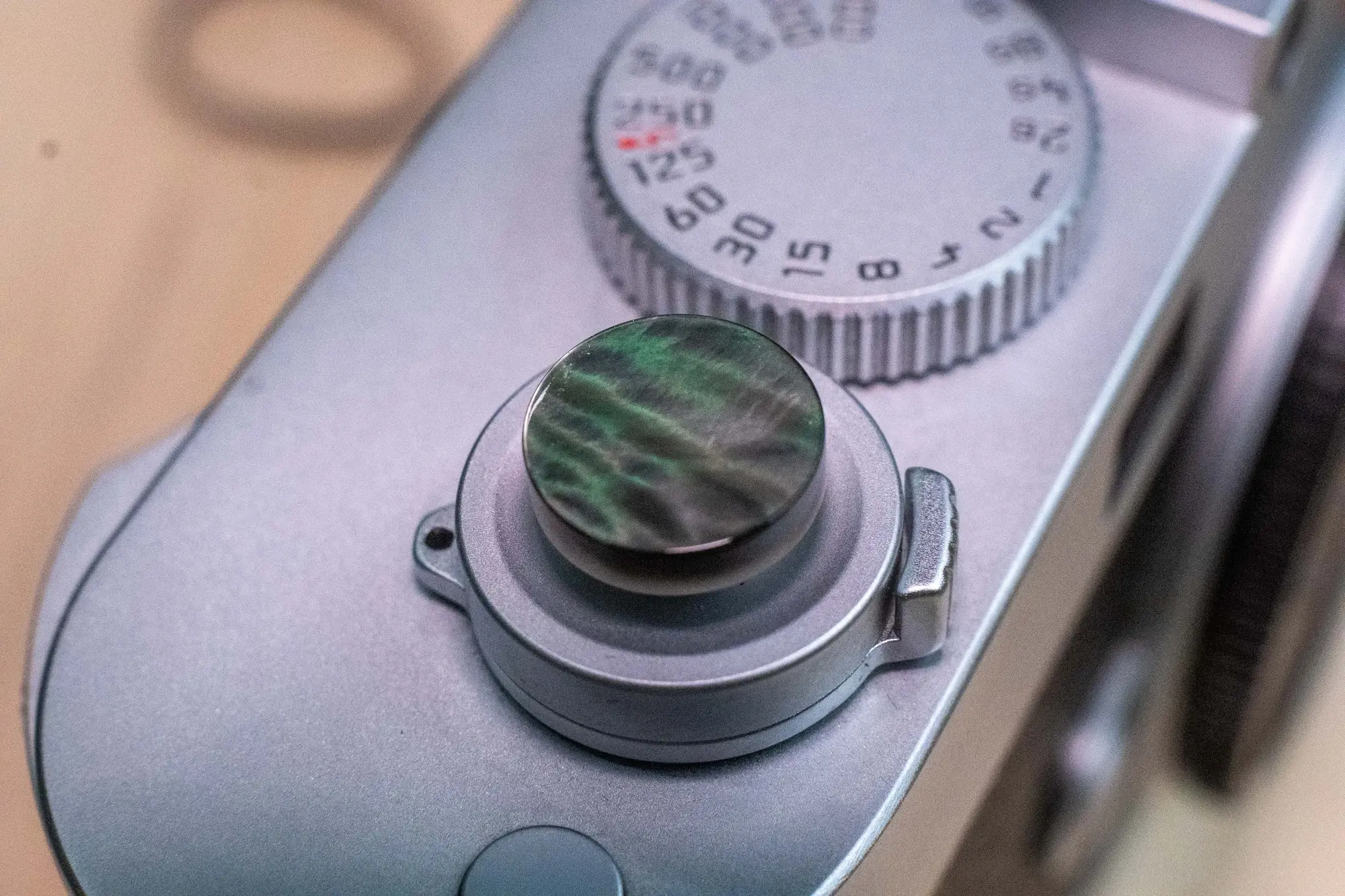 Green mother-of-pearl shutter button on a camera